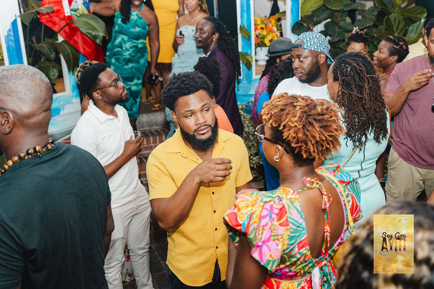 Crowd of guests mingling by the blue courtyard mural during an event at Stem & Vine in Baltimore
